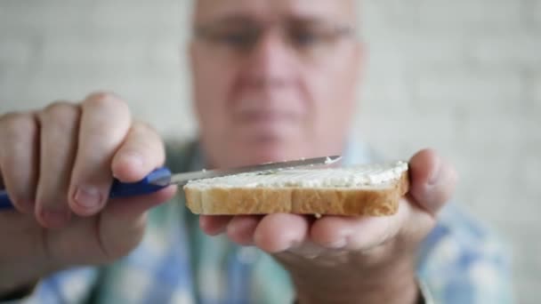 Mann macht ein leckeres Sandwich mit frischem Toast, Butter und Käse zum Frühstück. — Stockvideo