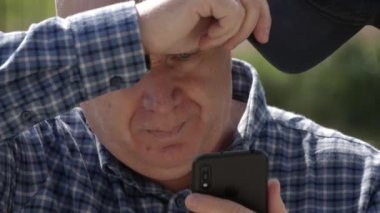 Sıkıcı kişi cep telefonundan mesajlar gönderiyor ve okuyor. Cep Telefonu Bağlantısını Kullanarak Üzücü Adam Metni.