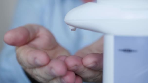 Hombre en el baño lavándose las manos usando jabón de gel usando un dispensador de jabón eléctrico. — Vídeo de stock