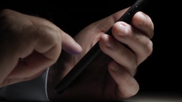 Um homem texto em um telefone celular, enviar e receber mensagens usando a Internet. Usando um telefone celular tarde, à noite. — Vídeo de Stock