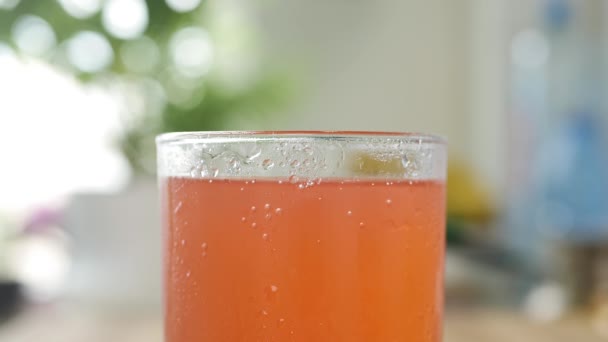 Um copo com bebida de laranjas fria, doce, acidificada e refrescante. Tiro com um copo com bebida fresca saborosa. — Vídeo de Stock