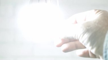 Bir el elektrik düğmesinin kordonunu çeker ve ampulü kapatır. Bir Odada Işığı Durdurmak ve Başlatmak için kullanılan Cord Teknolojisini Değiştir.