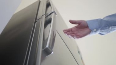 Susamış Kişi Kapı Dolabını Açar ve Taze Suyla Bir Şişe İçine Koyar.