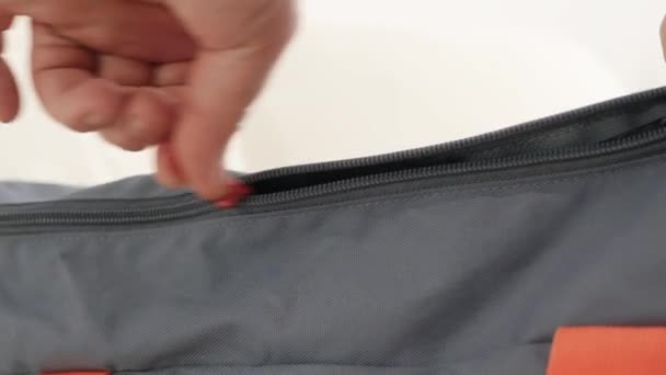 Close Up Shooting with a Hand Opening a Zipper from a Sports Bag and Taking Out Some Clothes. — Stock Video