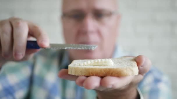 Persona haciendo un delicioso sándwich esparciendo la mantequilla con un cuchillo en un brindis fresco para el desayuno. — Vídeo de stock