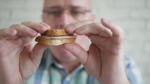 Uitgehongerde persoon Eet een heerlijke sandwich met ham en boter bij het ontbijt. hebzuchtige en hongerige man eten van een snack. — Stockvideo