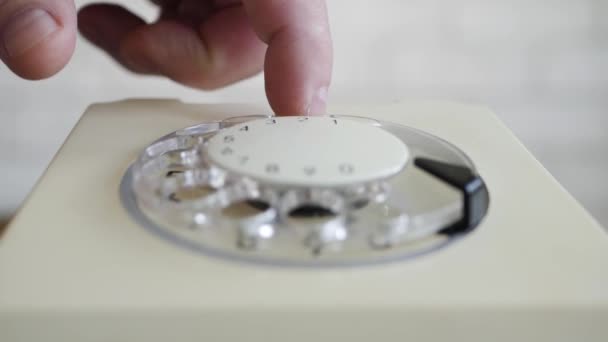 Hombre usando un teléfono, girando el disco y marcando un número de teléfono. Tecnología de línea fija antigua utilizada para la comunicación por cable. — Vídeos de Stock