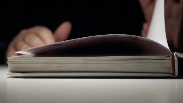 A Hand Flipping Through the Pages of an Open Book. Man Reading and Learning Late at Night from a Book. — Stock Video