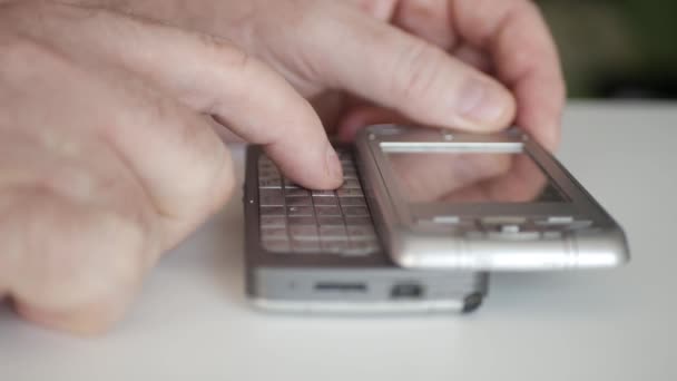 En person ringer ett telefonnummer med hjälp av en gammal mobiltelefon med löstagbar knappsats. Man Text Använda en gammal teknik mobiltelefon. — Stockvideo