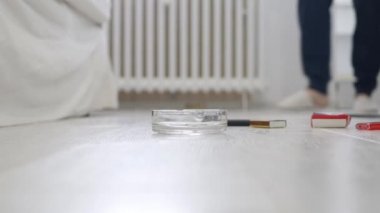 Yatakta oturan, sigara içen ve içki içen bir insanla çekim yapmak..