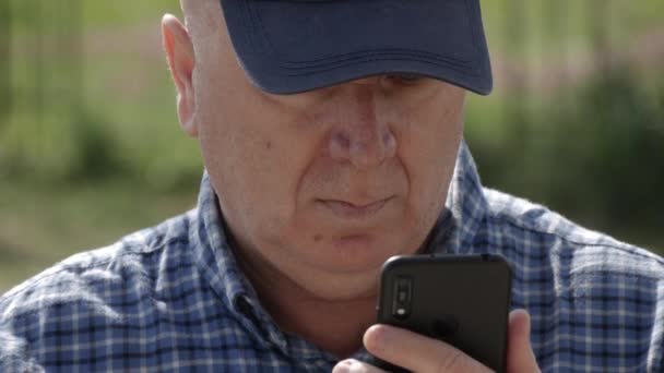 Znudzony i zdenerwowany Wysyłanie i czytanie wiadomości z jego telefonu komórkowego. Man Text Korzystanie z połączenia z telefonem komórkowym. — Wideo stockowe
