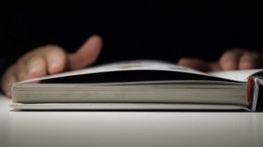 Açık Bir Kitabın Sayfalarını Elle Çevirme. Gece geç saatlerde bir kitaptan okuma ve öğrenme.