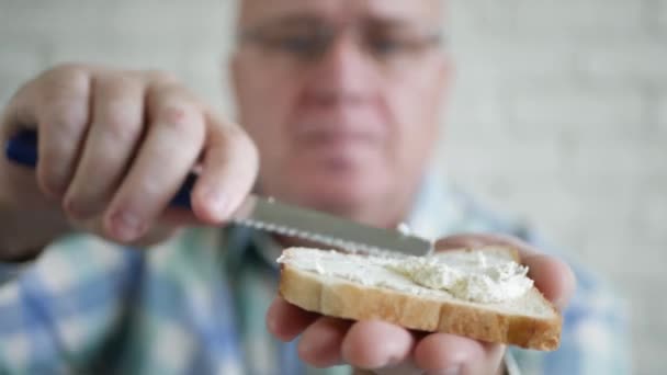 L'homme fait un délicieux sandwich avec du pain grillé frais, du beurre et du fromage pour le petit déjeuner. — Video