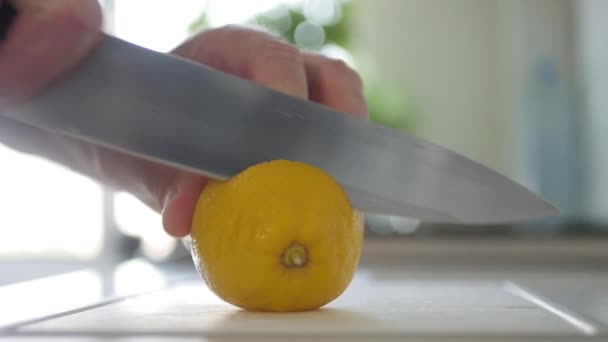 Κόβω μια χυμώδη φέτα από ένα νόστιμο φρέσκο λεμόνι. Φυσική και υγιεινή διατροφή. Vegan Διατροφή με Φρούτα και Βιταμίνες. — Αρχείο Βίντεο