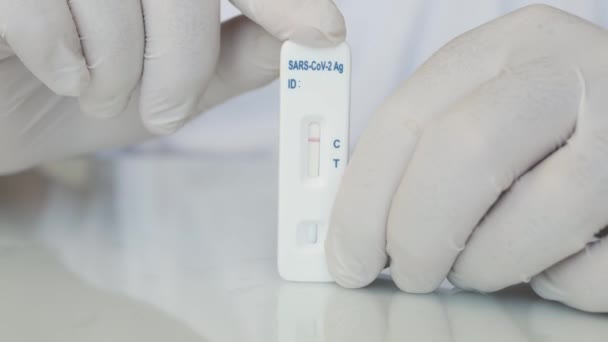 Sparare con un medico Tenendo in mano un test rapido di Coronavirus. Test negativo di Sars Cov 2 tenuto in mano da un'infermiera in un ospedale. — Video Stock