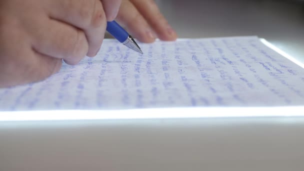 Geschäftsmann, der einen handgeschriebenen Vertrag auf einer Papierseite liest. Student überprüft einen Text, der auf einer Papierseite geschrieben wurde. — Stockvideo