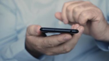 İş adamı cep telefonundan mesaj atıyor. Akıllı telefon kullanarak internet sayfalarına göz atıyorum. Cep Telefonu Kullanan Adam.