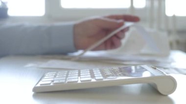 Faturalarla çalışan işadamı, Ekleme Makinesiyle Finansal Hesaplamalar Yapıyor. Muhasebe ücreti ve Vergi Hesaplamaları.