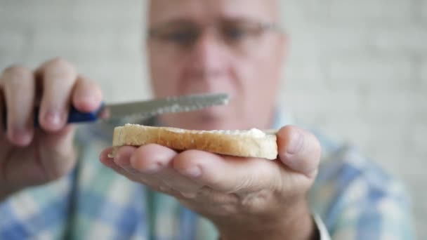制作美味三明治的人在新鲜的面包上用刀叉在黄油上撒早餐 — 图库视频影像