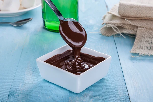 Schokoladensauce fließt vom Löffel herunter — Stockfoto
