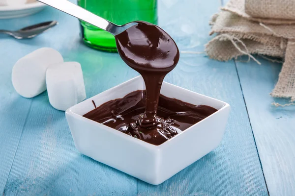 La salsa de chocolate desciende de una cuchara — Foto de Stock