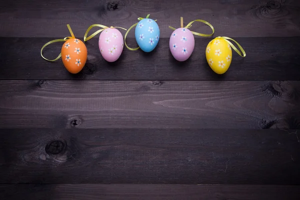 Painted eggs on black wood — Stock Photo, Image