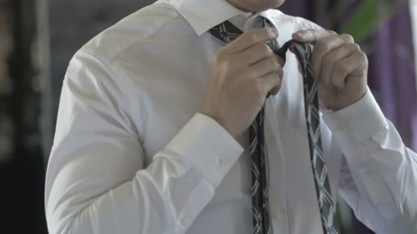 Homem de negócios em uma camisa branca amarrando sua gravata — Vídeo de Stock