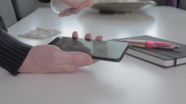 Akıllı telefon ekranını alkolle temizleyen adam..