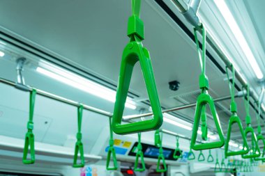 Banliyö trenlerindeki tırabzanlar yeşil.