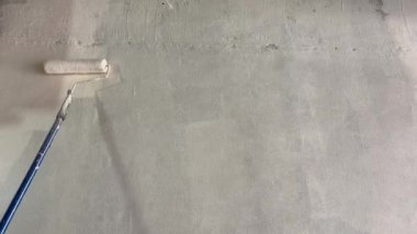 Bir silindirle boyama aktivitesi. Duvar boyama işçileri silindir kullanır..