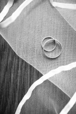 Alyans üzerinde tahta bir masanın üzerinde yatan tül