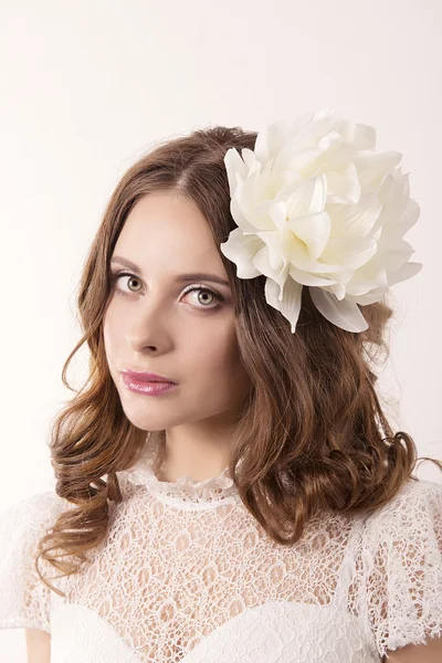Niña en vestido blanco y con flor blanca en el pelo — Foto de Stock