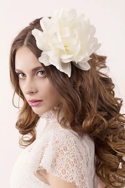 Niña en vestido blanco y con flor blanca en el pelo — Foto de Stock