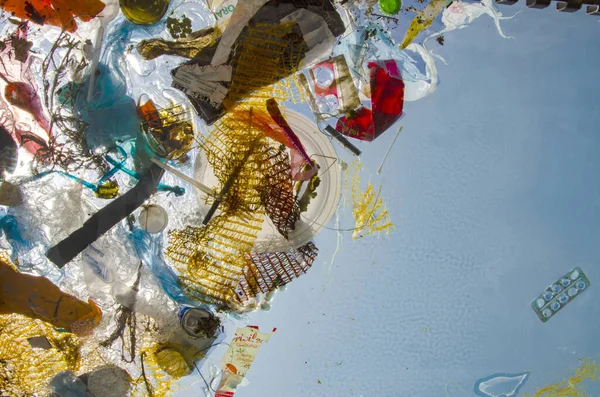 Pollution of ocean, water. Plastic and debris float in water. Packages and cans were thrown into sea.