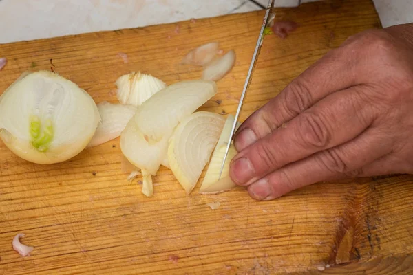 Cutting onion in kitchen — Stock Photo, Image