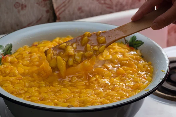 Mixing with wooden spatula peach jam in bowl — Stock Photo, Image