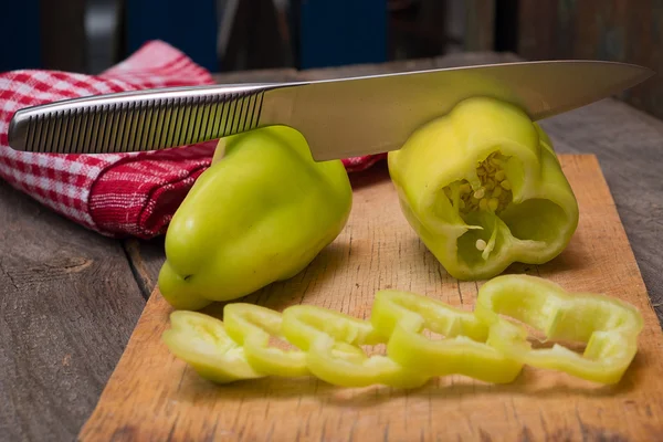 Foto av skivad grön paprika över träbord — Stockfoto