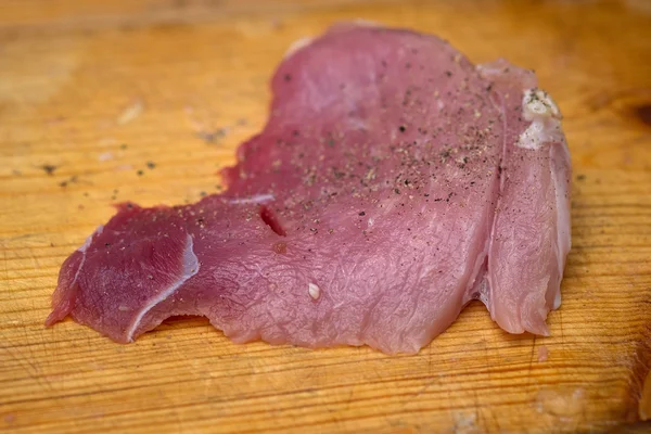Nahaufnahme menin der Küche schneidet Schweinefleisch auf Schneidebrett — Stockfoto
