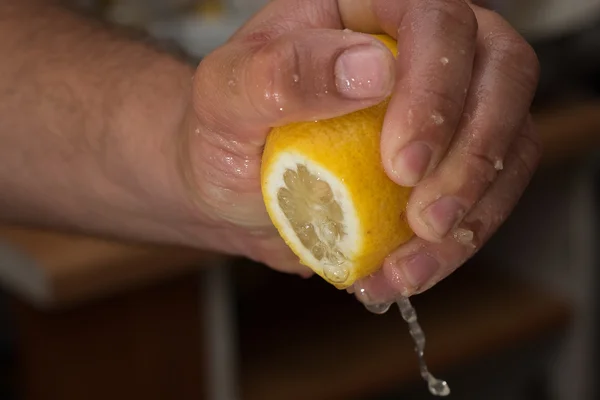 Esprema o suco de limão na mão Imagem De Stock