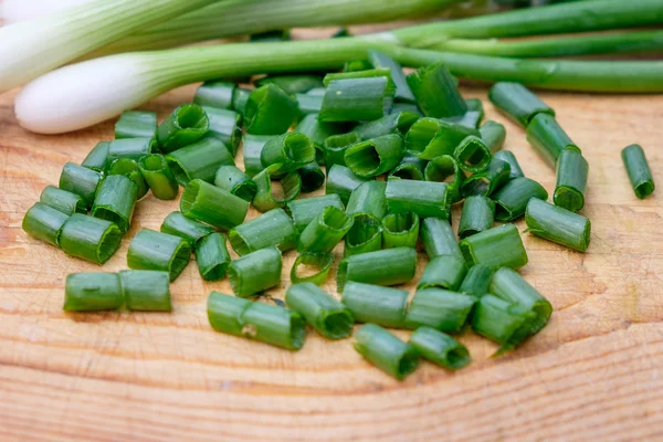 Cebollas verdes frescas en escritorio de cocina de madera —  Fotos de Stock