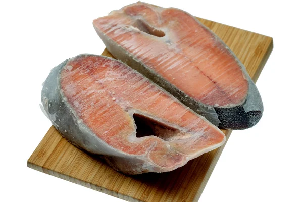 Frozen salmon steak on wooden desk