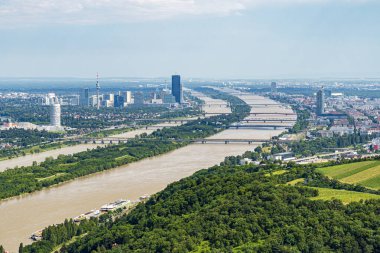 Tuna Nehri, köprüler ve aydınlık bir gökyüzü altında modern gökyüzü olan Viyana şehir manzarası, Avusturya.