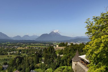 Bereketli ormanları, uzak dağları olan geniş manzaralı bir vadi ve berrak bir yaz gününde açık mavi gökyüzünün altında tarihi bir kale duvarı..