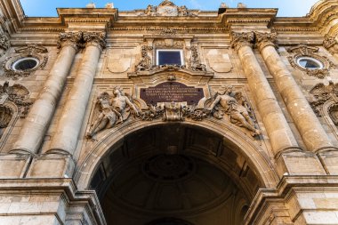 Barok taş kemerini klasik heykeller ve sütunlarla süsleyin, aşağıdan bakın. Zengin detayları, simetrisi ve zamansız atmosferi olan tarihi Avrupa mimarisi.