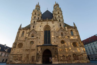 Avusturya 'nın Viyana kentindeki St. Stephen Katedrali' nin ön görüntüsü, süslü taş cepheli ve desenli çatısı olan Gotik bir simge, temiz bir gökyüzü altında altın saatinde ele geçirilmiş, tarihi Avrupa ihtişamını aktarıyor..
