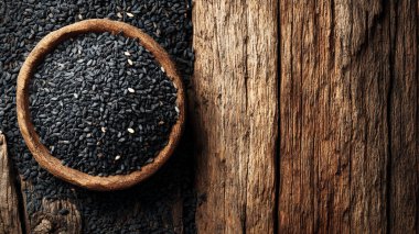 Tahta arka planda siyah susam tohumları.