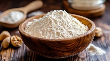 Tahta masada un, kaşık ve bir kase buğday.