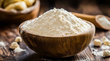 Tahta yüzeyde un ve oklavalı kase, yakın plan.