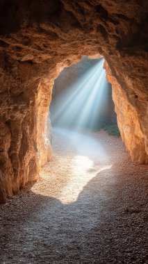 Arka planda parlayan güneş ışığı olan bir taş tünelin dikey görüntüsü.,