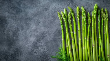 Ahşap arka planda taze yeşil yapraklı kuşkonmaz..